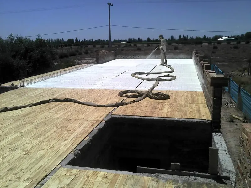 Operario proyectando poliuretano expandido sobre un techo de madera